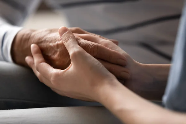 Hija adulta cogida de la mano de la madre anciana expresa protección — Foto de Stock