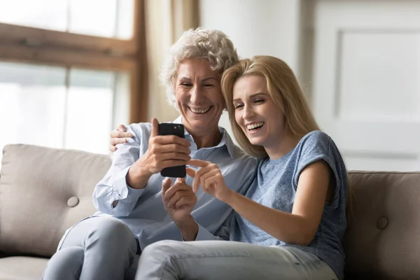 Взрослая старушка с помощью смартфона ведет видеоконтакт с родственниками — стоковое фото