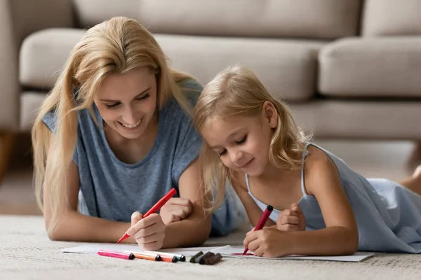 Família encontra-se no chão desenha com canetas coloridas da feltro-ponta — Fotografia de Stock