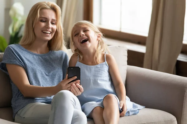 Filha e mãe assistindo vídeos engraçados usam smartphone se sente muito feliz — Fotografia de Stock