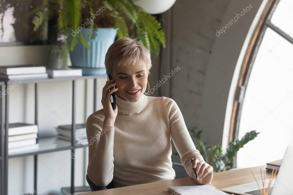 Businesswoman holding smartphone having peasant positive conversation with corporate client