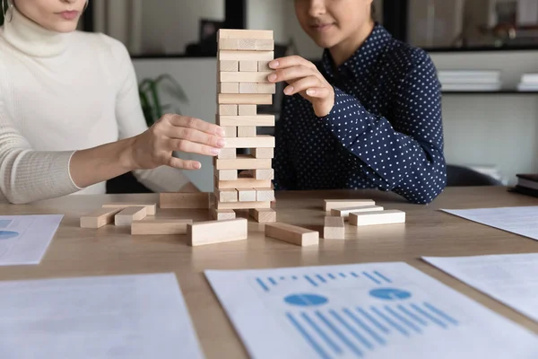 Multirazziale imprenditrici giocare costruire blocco di legno stacking gioco sul posto di lavoro — Foto Stock