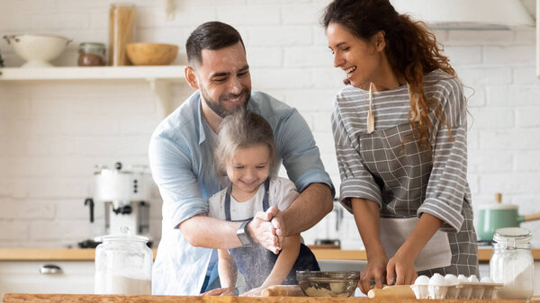 Happy father clapping hands with flour hugging daughter near mother.