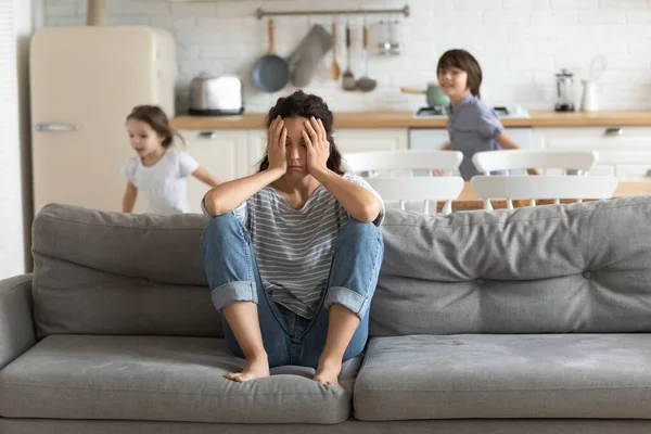 Hiperactivos niños cansados y corriendo cerca de madre molesta . — Foto de Stock