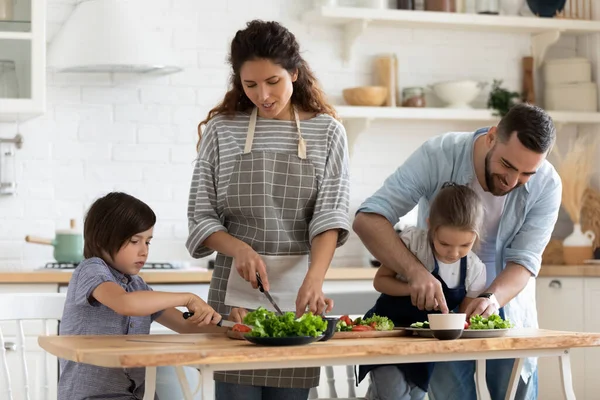 Zorgzame vader en moeder leren kleine kinderen top gebruik mes. — Stockfoto