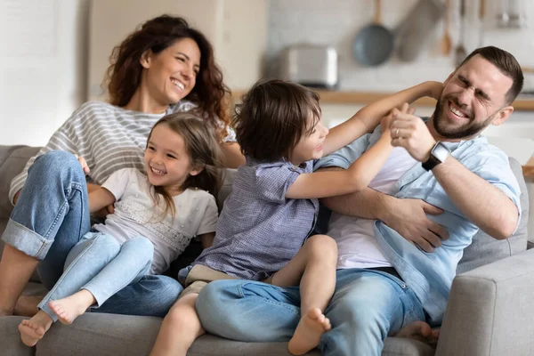 Close up gelukkig voorschoolse jongen kietelen jong vader. — Stockfoto