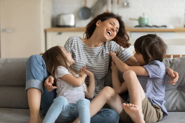 Feliz bonito filha e filho cócegas jovem atraente mãe . — Fotografia de Stock