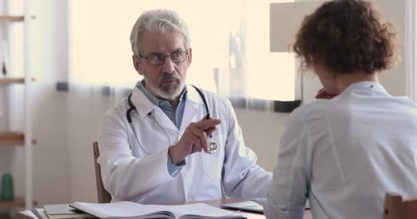 Grave concentrato medico hoary di mezza età consulenza paziente femminile. — Video Stock