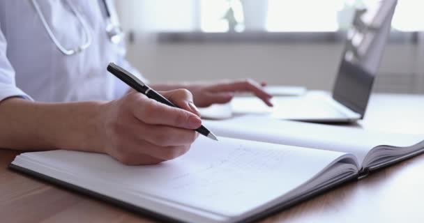Primer plano joven médico escribiendo notas en el álbum de registro . — Vídeos de Stock