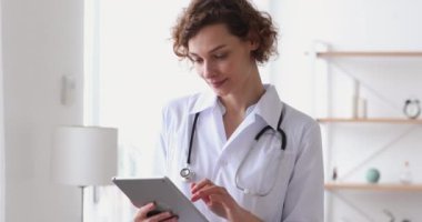 Gülümseyen genç kadın terapist tablet üzerinde online sağlık uygulaması kullanıyor..