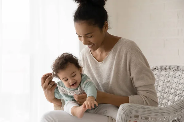 Söt liten småbarn flicka sitter på leende mor varv — Stockfoto