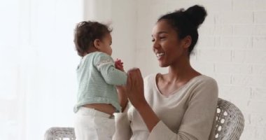 Sevgi dolu, mutlu, Afrikalı bir anne. Küçük tatlı oğluyla oynuyor..