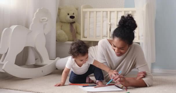Loving gemengde ras moeder onderwijs weinig zuigeling tekening foto 's. — Stockvideo