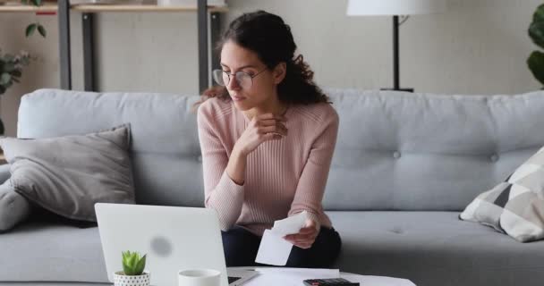 Geconcentreerde dame berekent inkomens uitkomsten nutsrekeningen. — Stockvideo