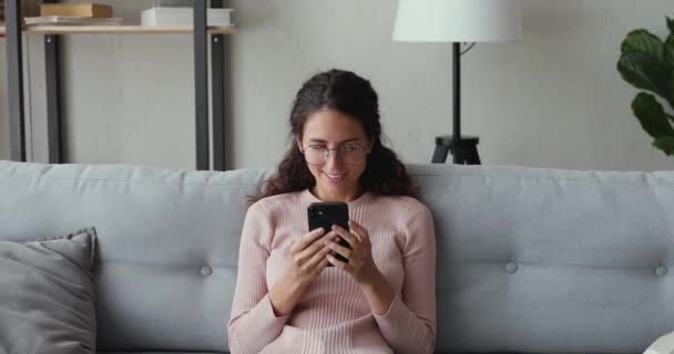 Relaxed beautiful woman enjoying chatting with friends in mobile app. — Stock Video