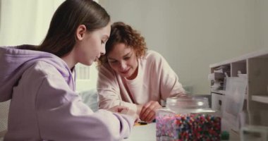 Gülümseyen anne evde genç kızıyla oynuyor..