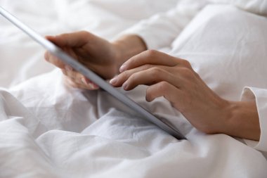 Yatakta tablet kullanan kadına yaklaş.