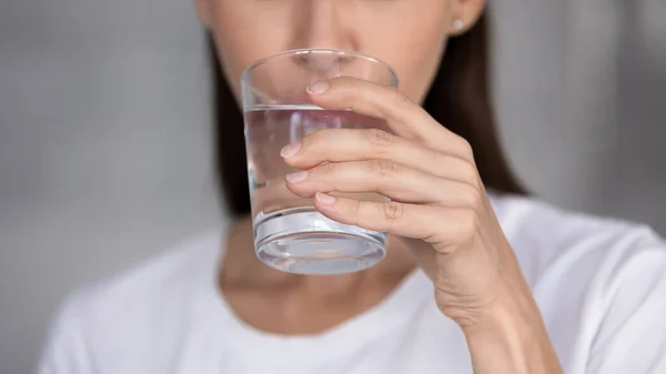 Jovem sedenta bebendo água mineral pura — Fotografia de Stock