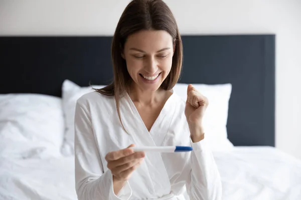 Overblijde vrouw vieren positieve zwangerschapstest resultaten — Stockfoto