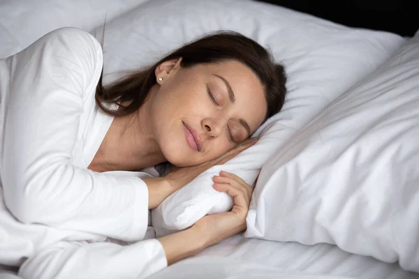 शांत तरुण स्त्री आराम आरामदायक बेड मध्ये झोप — स्टॉक फोटो, इमेज