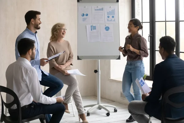 Diverse employees having fun with Indian mentor at corporate meeting