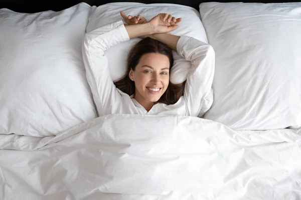 Wanita bahagia berbaring santai di tempat tidur nyaman di rumah — Stok Foto