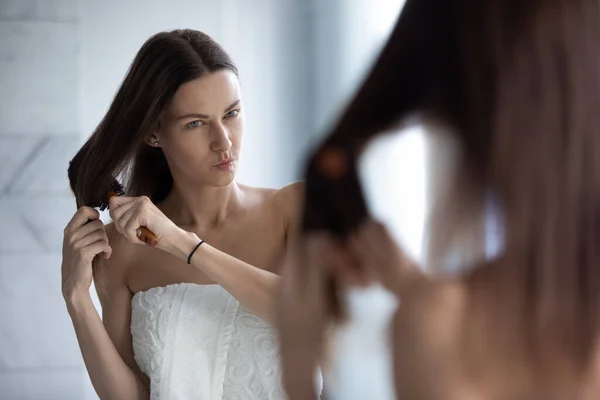 Ongelukkige vrouw borstel verstrengeld lang haar in de badkamer — Stockfoto