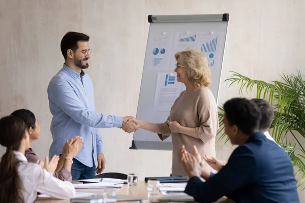 Führende Unternehmerin mittleren Alters schüttelt erfolgreiche Angestellte die Hand — Stockfoto