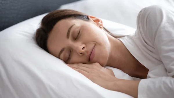 평온 한 젊은 여자는 침실에서 편안 히 잠을 잔다 — 스톡 사진