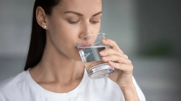 Жаждущая женщина пьет чистую воду из стекла — стоковое фото