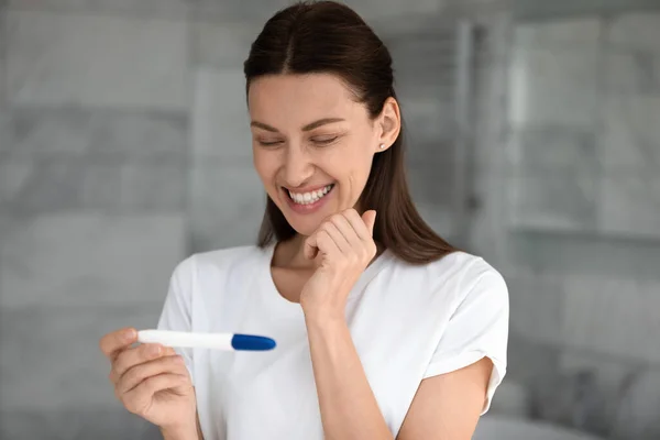 Overjoyed woman happy with positive pregnancy test results — Stock Photo, Image