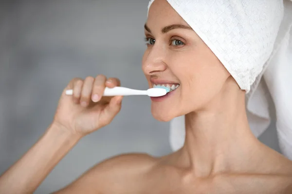 Smiling woman look in mirror brush teeth with toothbrush — Stock Photo, Image