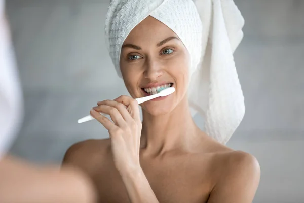 Jonge vrouw poetsen tanden met tandenborstel en tandpasta — Stockfoto
