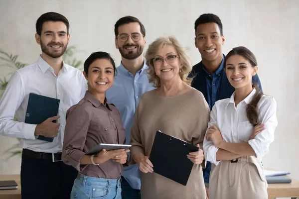 Corporate portrait smiling diverse employees team standing in office