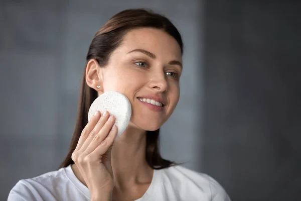 Smiling female look in mirror do facial skincare procedures — Stock Photo, Image