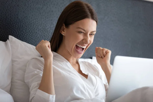 Excited woman scream winning lottery on laptop Stock Photo