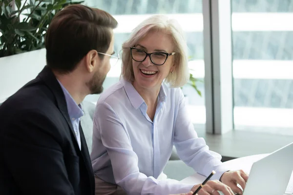 Elderly businesswoman sitting next to subordinate — Stock Photo, Image