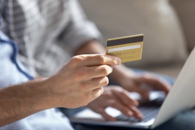 Plastik kredi kartı tutan adam, internetten alışveriş yapan çift.