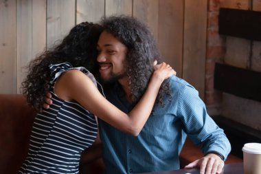 Sarılan Afrikalı çift romantik bir randevu sırasında kafede oturur.