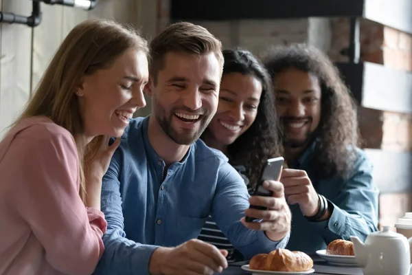 Amici che si divertono usano smartphone guardando video in caffè — Foto Stock