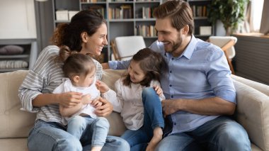İki çocuklu mutlu bir aile oturma odasında eğleniyor.