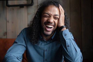 Komik, neşeli, uzun saçlı, şakayla gülen Afrikalı adam.