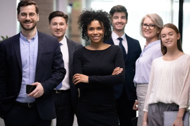 Kendine güvenen Afro-Amerikan iş kadını patronu ve mutlu iş adamları takımı.