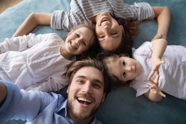 Üst tabaka mutlu genç aile yatakta birlikte yatıyor.