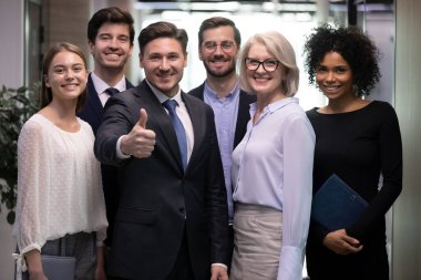 Çeşitli mutlu çalışanlardan oluşan bir ekibi olan başarılı bir yetişkin iş adamı.