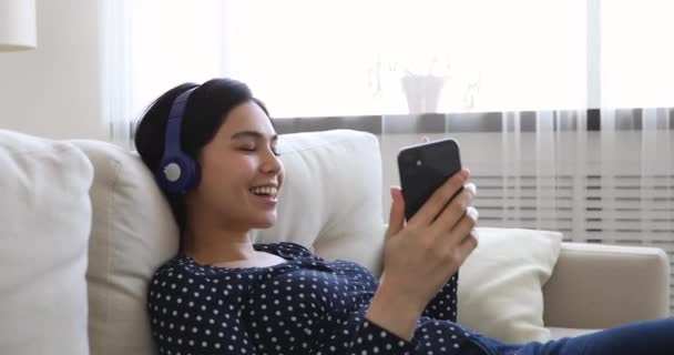 Asijská žena odpočívá ve sluchátkách pomocí smartphone zpěv píseň — Stock video