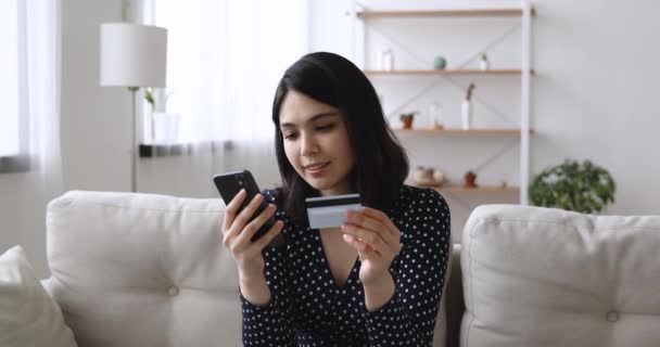 Ευτυχισμένη Ασιάτισσα γυναίκα κρατώντας κινητό τηλέφωνο χρησιμοποιώντας πιστωτική κάρτα κάνει την αγορά — Αρχείο Βίντεο