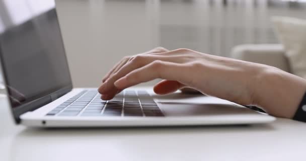 Primeros planos manos femeninas escribiendo en el ordenador portátil sentado en la mesa — Vídeo de stock