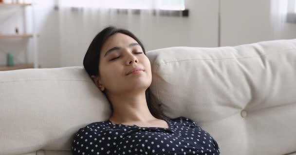 Mulher asiática inclinada no sofá olhos fechados relaxando em casa — Vídeo de Stock