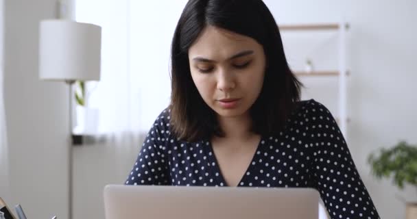 Σοβαρή ασιατική φοιτητής κάνει ανάθεση προετοιμασία για εξετάσεις χρησιμοποιώντας φορητό υπολογιστή — Αρχείο Βίντεο